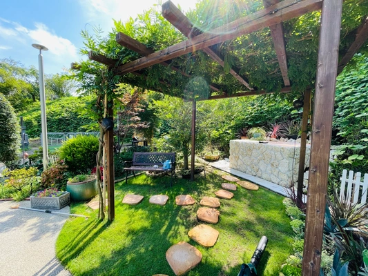 シンボルツリーの下にプレートが並ぶ樹木葬霊園の風景