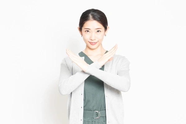 バツのジェスチャーをする女性